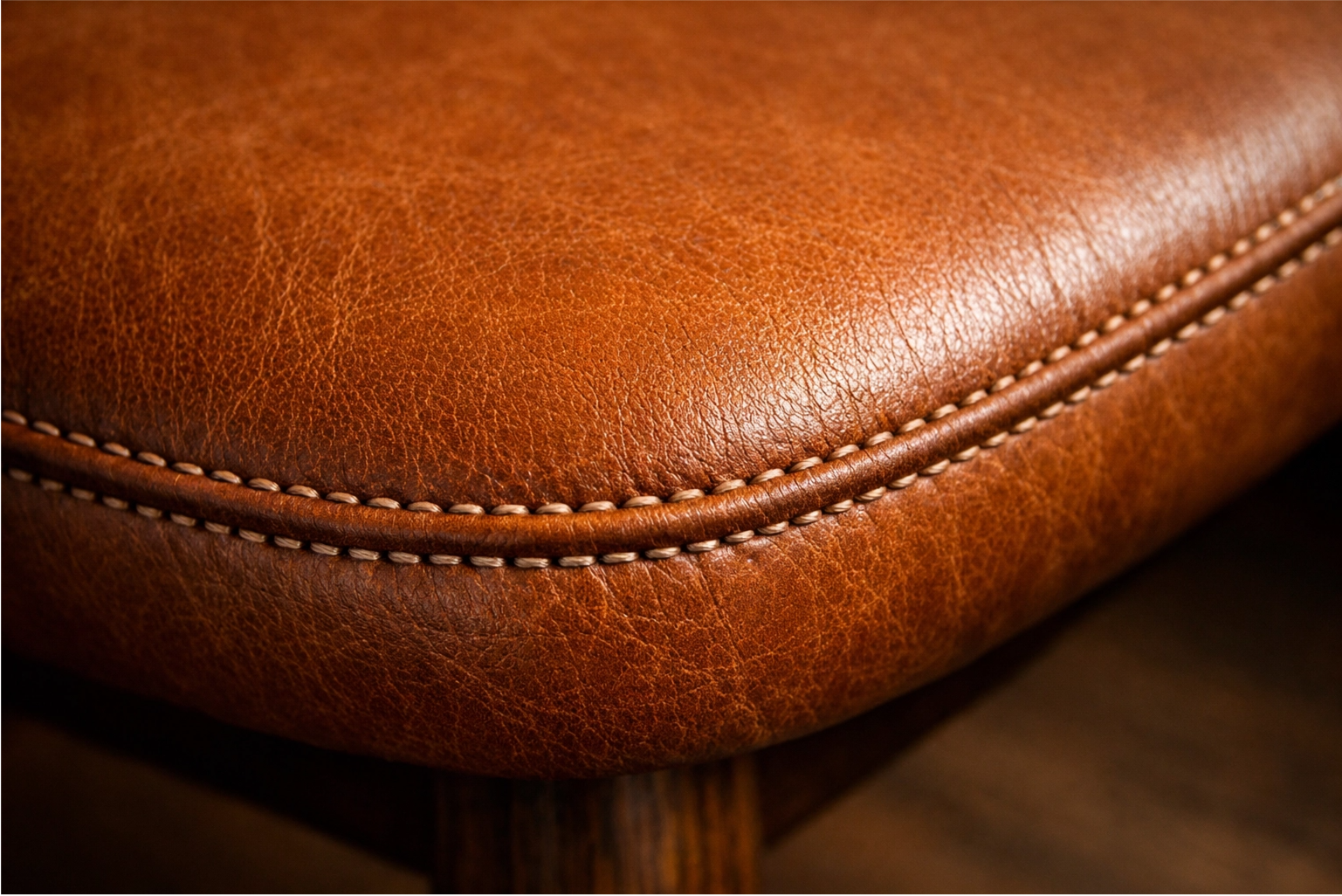 A close-up of a high-quality leather dining chair seat, showing its rich texture and durability